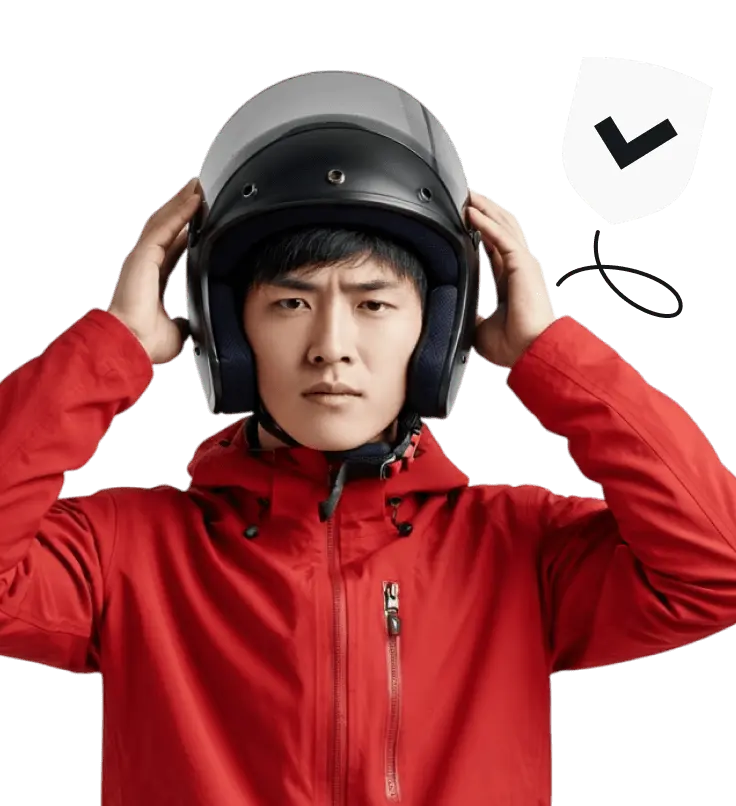 A man in a red jacket putting on a helmet.